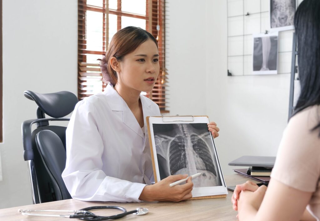 Doctor showing x-ray result to patient in clinic.