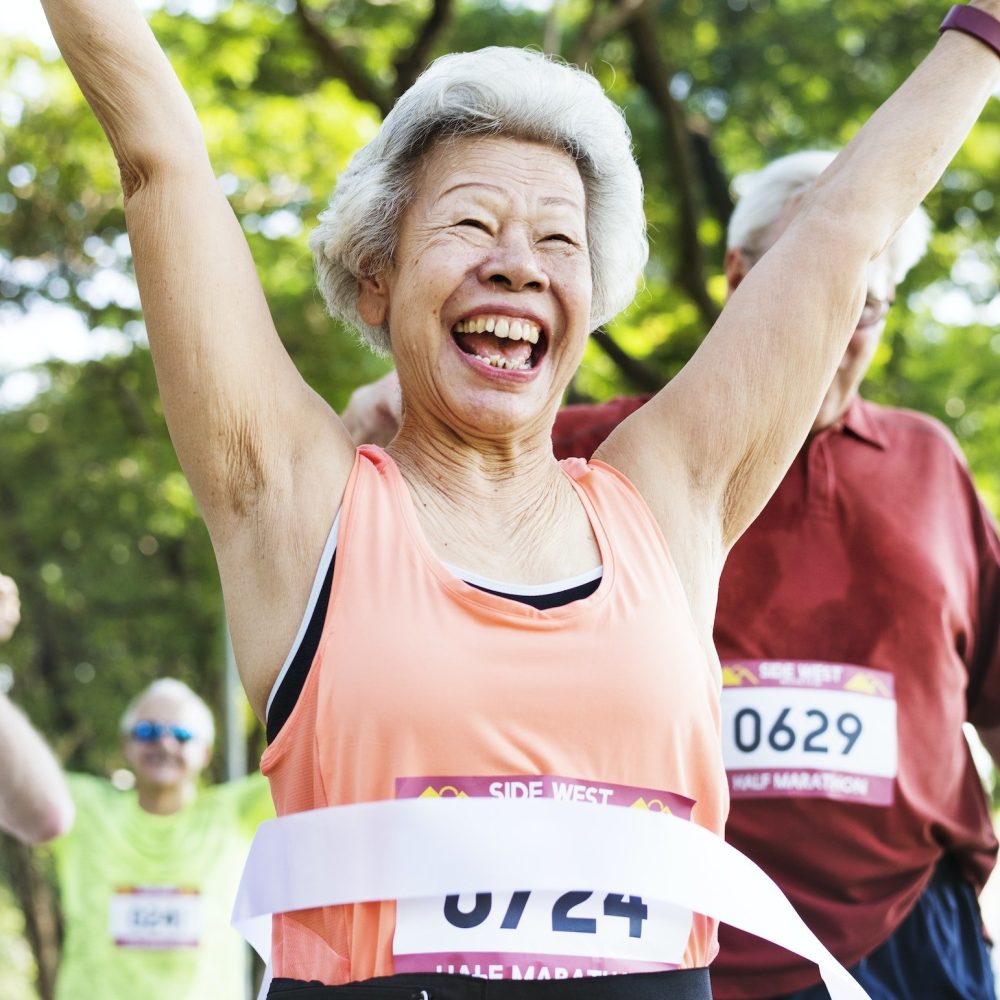 Elderly asian woman reaching the finish line