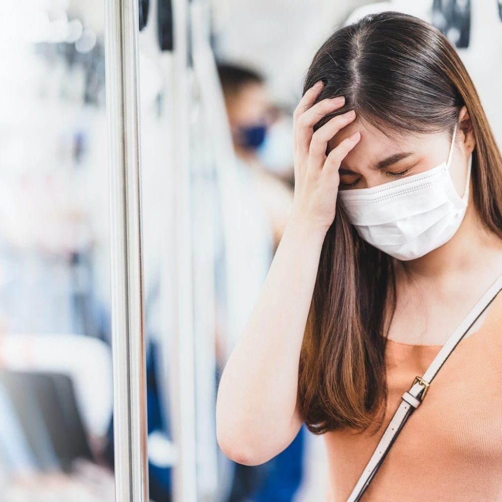 Young Asian woman passenger wearing surgical mask and Having a headache in subway train Young Asian woman passenger wearing surgical mask and Having a headache in subway train